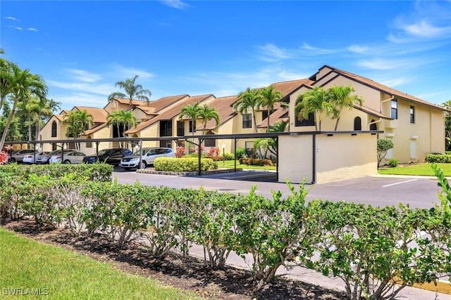 8336 Charter Club Cir Unit 10, Fort Myers, FL 33919 - view of front of property featuring covered and uncovered parking, stucco siding, and a residential view