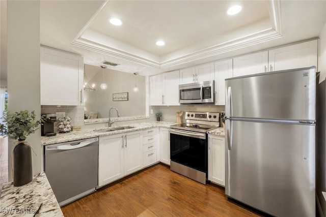 8336 Charter Club Cir Unit 10, Fort Myers, FL 33919 - kitchen featuring appliances with stainless steel finishes, a sink, a raised ceiling, white cabinetry, and tasteful backsplash