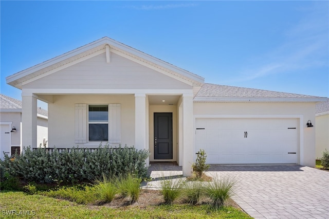16678 Expedition Ct, Punta Gorda, FL 33982 - view of front facade with decorative driveway, a garage, and covered porch