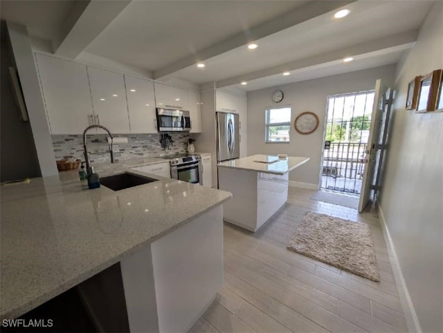 2111 Barkeley Ln Unit 13, Fort Myers, FL 33907 - kitchen with stainless steel appliances, baseboards, beamed ceiling, a kitchen island, and backsplash