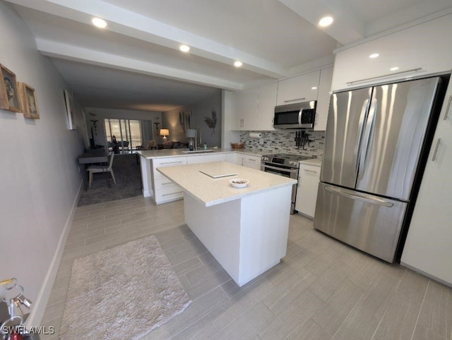 2111 Barkeley Ln Unit 13, Fort Myers, FL 33907 - kitchen with appliances with stainless steel finishes, a peninsula, white cabinetry, beam ceiling, and a sink