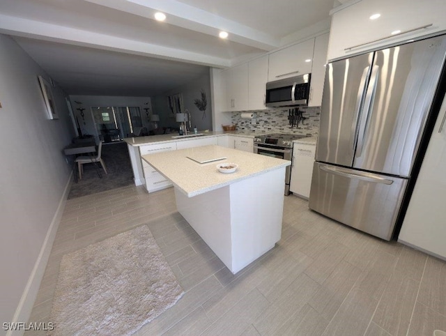 2111 Barkeley Ln Unit 13, Fort Myers, FL 33907 - kitchen featuring stainless steel appliances, light countertops, a peninsula, white cabinets, and decorative backsplash