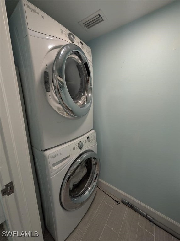 2111 Barkeley Ln Unit 13, Fort Myers, FL 33907 - laundry room with estacked washer and dryer and baseboards