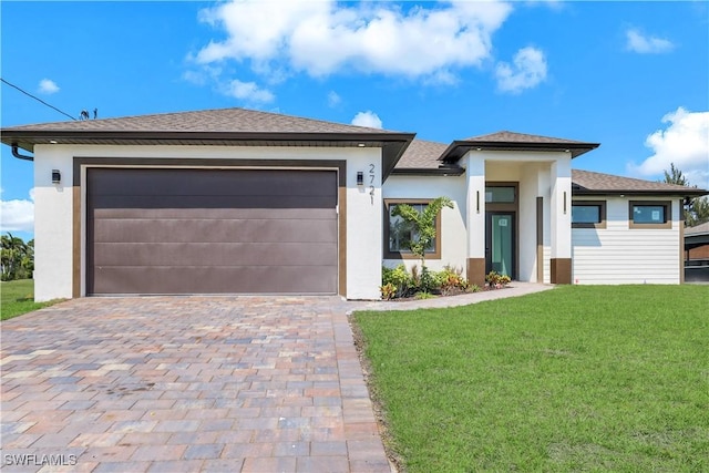 2721 NW 10th Ter, Cape Coral, FL 33993 - prairie-style house featuring a front yard, driveway, stucco siding, an attached garage, and a shingled roof