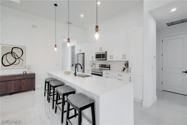 2721 NW 10th Ter, Cape Coral, FL 33993 - kitchen featuring appliances with stainless steel finishes, a sink, a kitchen breakfast bar, white cabinets, and a center island with sink