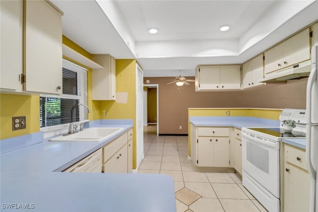 kitchen with white appliances, a sink, a peninsula, light countertops, and under cabinet range hood