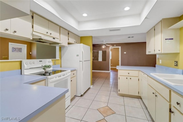 kitchen with under cabinet range hood, white appliances, a peninsula, light countertops, and cream cabinets