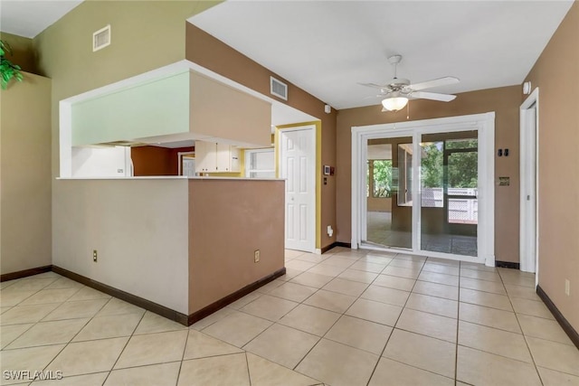 unfurnished room featuring ceiling fan, baseboards, and light tile patterned floors