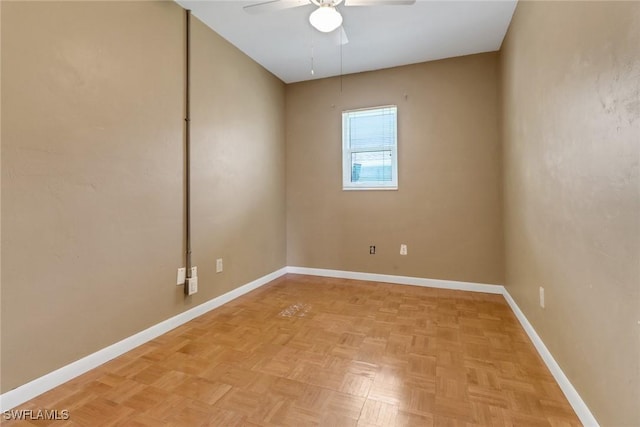 spare room with ceiling fan and baseboards
