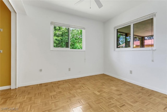 empty room with a ceiling fan and baseboards