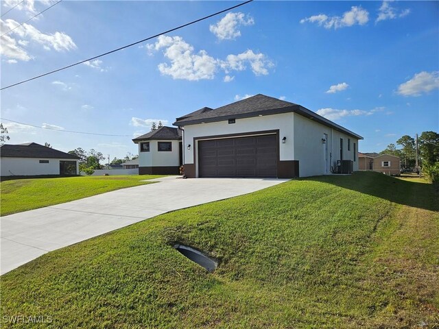 3418 12th St W, Lehigh Acres, FL 33971 - view of front of home featuring driveway, stucco siding, a front lawn, a garage, and central AC