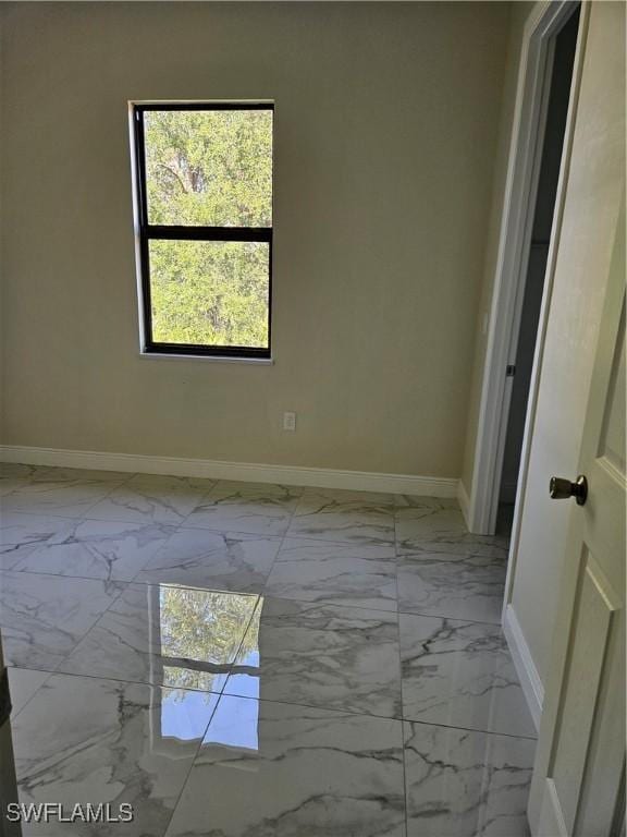 3418 12th St W, Lehigh Acres, FL 33971 - spare room featuring light marble finish flooring and baseboards