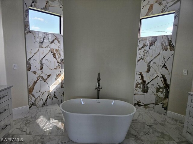 3418 12th St W, Lehigh Acres, FL 33971 - bathroom with marble finish floors, healthy amount of natural light, a freestanding tub, and vanity