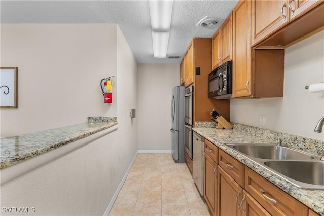 25100 Sandhill Blvd Unit R202, Punta Gorda, FL 33983 - kitchen featuring stainless steel appliances, a sink, brown cabinetry, baseboards, and light tile patterned floors
