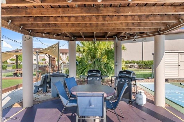 25100 Sandhill Blvd Unit R202, Punta Gorda, FL 33983 - view of patio / terrace with fence, shuffleboard, a grill, and outdoor dining area