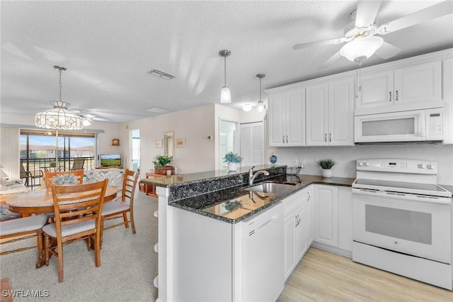 25100 Sandhill Blvd Unit R202, Punta Gorda, FL 33983 - kitchen with white appliances, a sink, a peninsula, white cabinets, and a textured ceiling