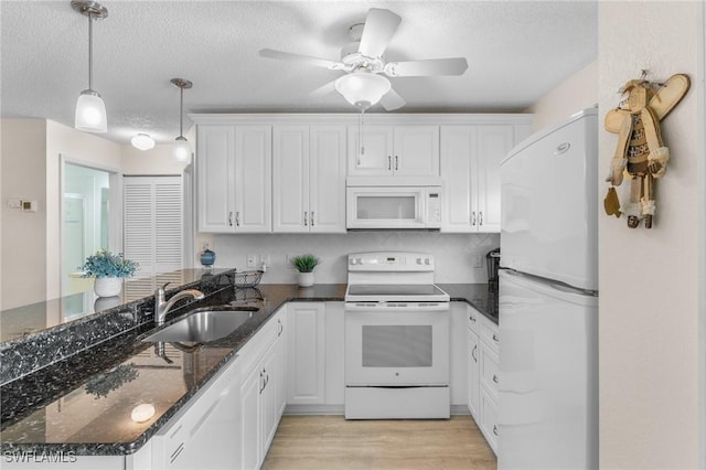 25100 Sandhill Blvd Unit R202, Punta Gorda, FL 33983 - kitchen featuring white appliances, a sink, white cabinets, light wood-style flooring, and a textured ceiling