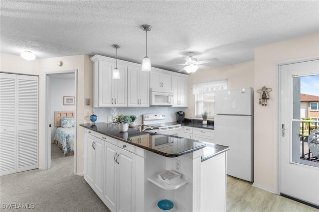 25100 Sandhill Blvd Unit R202, Punta Gorda, FL 33983 - kitchen featuring white appliances, open shelves, a peninsula, white cabinetry, and a ceiling fan