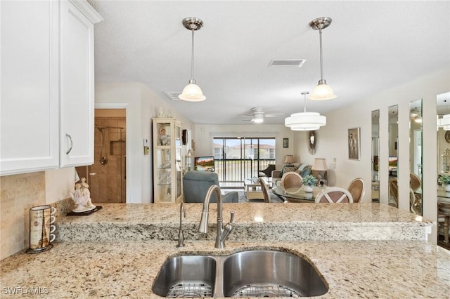 25100 Sandhill Blvd Unit 201, Punta Gorda, FL 33983 - kitchen featuring a sink, light stone counters, white cabinetry, and open floor plan