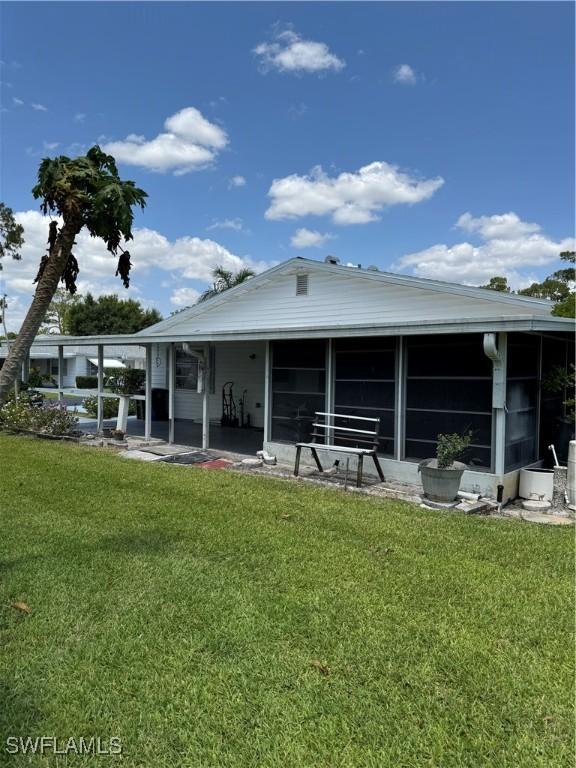5 Desert Candle Cir, Lehigh Acres, FL 33936 - back of house with a sunroom and a lawn
