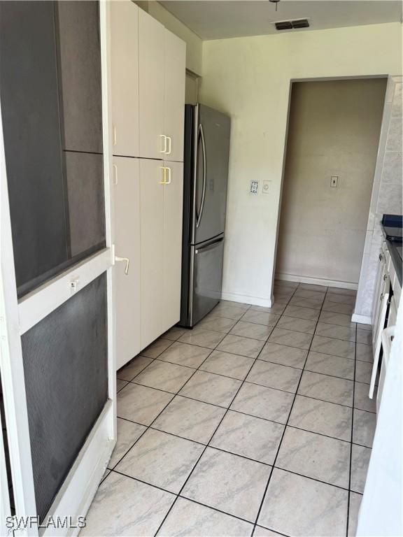 5 Desert Candle Cir, Lehigh Acres, FL 33936 - kitchen with freestanding refrigerator, light tile patterned floors, and baseboards