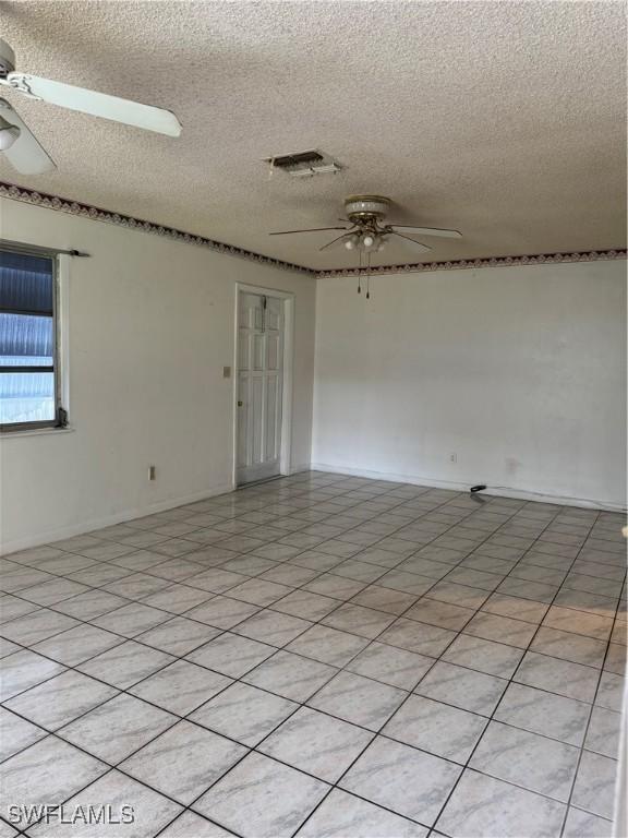 5 Desert Candle Cir, Lehigh Acres, FL 33936 - spare room with ceiling fan and a textured ceiling