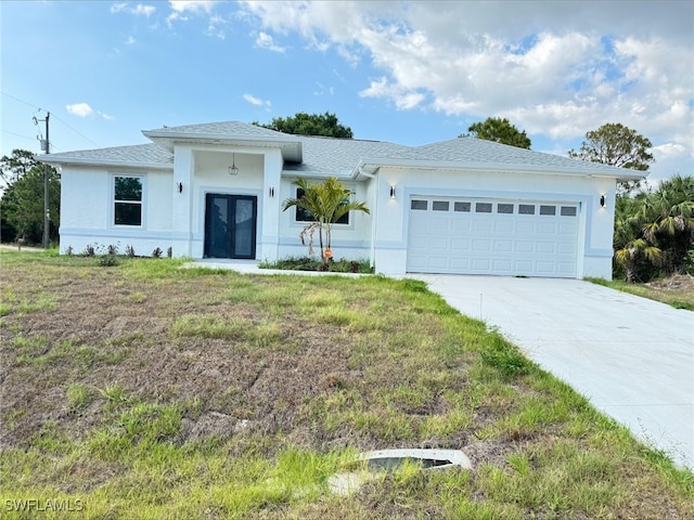 16 W 7th St, Lehigh Acres, FL 33972 - view of front of home with an attached garage, driveway, stucco siding, and french doors