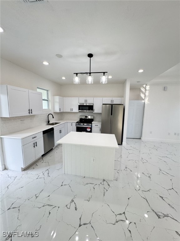 16 W 7th St, Lehigh Acres, FL 33972 - kitchen with stainless steel appliances, a sink, a kitchen island, white cabinets, and recessed lighting