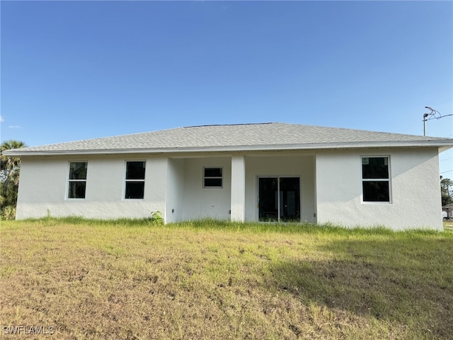 16 W 7th St, Lehigh Acres, FL 33972 - back of property with a yard, stucco siding, and roof with shingles