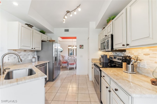 14521 Grande Cay Cir Unit 2902, Fort Myers, FL 33908 - kitchen with appliances with stainless steel finishes, a sink, white cabinets, light tile patterned flooring, and backsplash