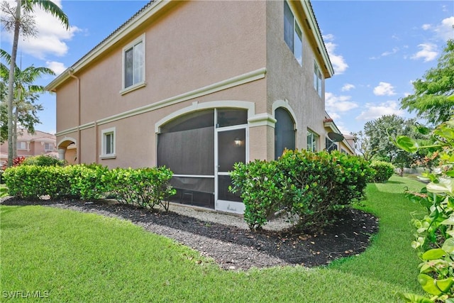 17504 Cherry Ridge Ln, Fort Myers, FL 33967 - view of property exterior with stucco siding, a lawn, and a sunroom