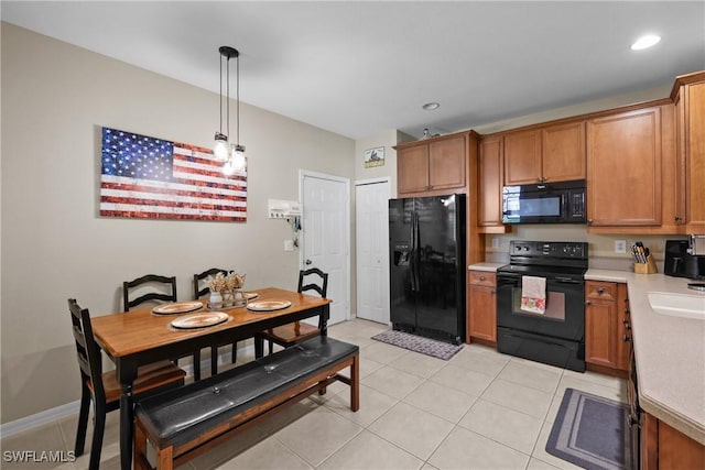 17504 Cherry Ridge Ln, Fort Myers, FL 33967 - kitchen featuring black appliances, brown cabinetry, light countertops, pendant lighting, and light tile patterned floors