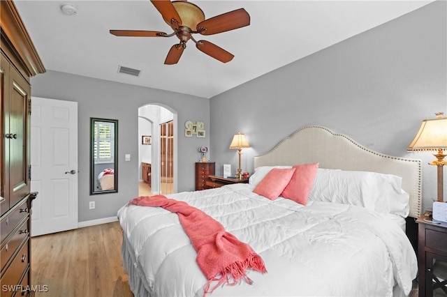 17504 Cherry Ridge Ln, Fort Myers, FL 33967 - bedroom featuring arched walkways, light wood-style flooring, ensuite bathroom, baseboards, and ceiling fan