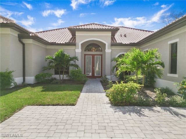 610 25th Ave NW, Naples, FL 34120 - entrance to property featuring french doors, stucco siding, and a tile roof