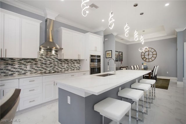 610 25th Ave NW, Naples, FL 34120 - kitchen featuring wall chimney exhaust hood, stainless steel double oven, light marble finish flooring, a sink, and ornamental molding