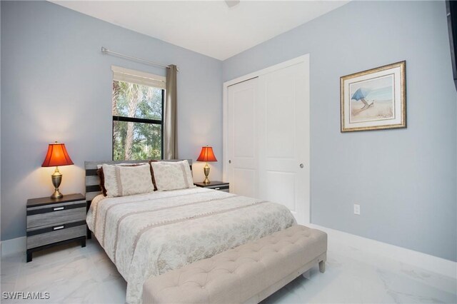 610 25th Ave NW, Naples, FL 34120 - bedroom with light marble finish flooring, a closet, and baseboards