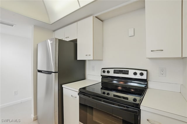 5220 Bonita Beach Rd SW Unit 105, Bonita Springs, FL 34134 - kitchen featuring electric range oven, light countertops, white cabinetry, and freestanding refrigerator