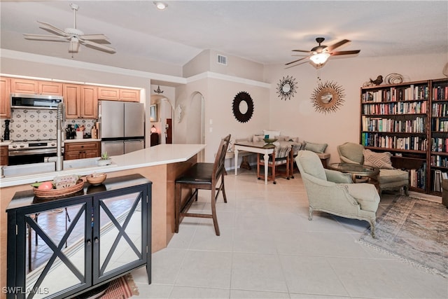 28427 Sabal Palm Dr, Punta Gorda, FL 33982 - kitchen with appliances with stainless steel finishes, a ceiling fan, a kitchen bar, light countertops, and lofted ceiling