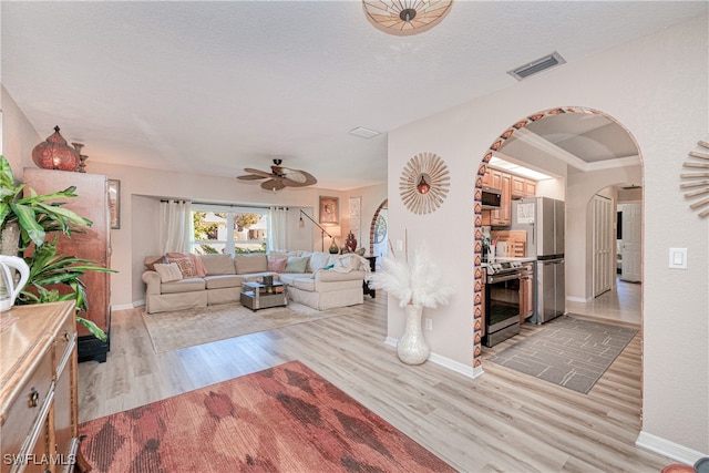 28427 Sabal Palm Dr, Punta Gorda, FL 33982 - living room with light wood finished floors, arched walkways, a ceiling fan, and baseboards