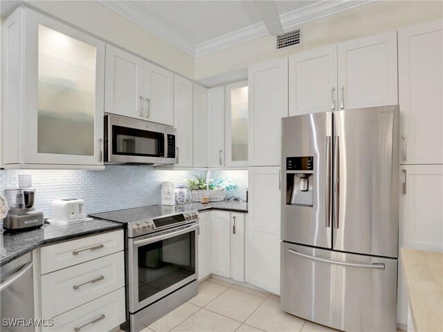 2110 Cay Lagoon Dr Unit 113, Naples, FL 34109 - kitchen featuring stainless steel appliances, crown molding, white cabinets, decorative backsplash, and light tile patterned flooring