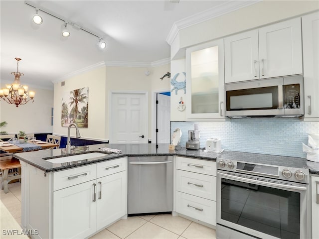 2110 Cay Lagoon Dr Unit 113, Naples, FL 34109 - kitchen with appliances with stainless steel finishes, a sink, light tile patterned flooring, a peninsula, and crown molding