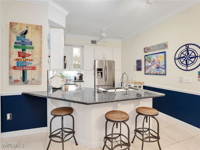 2110 Cay Lagoon Dr Unit 113, Naples, FL 34109 - kitchen featuring stainless steel fridge with ice dispenser, a sink, dark stone counters, light tile patterned floors, and white cabinetry