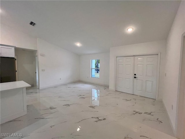 foyer entrance featuring baseboards, light marble finish floors, and recessed lighting