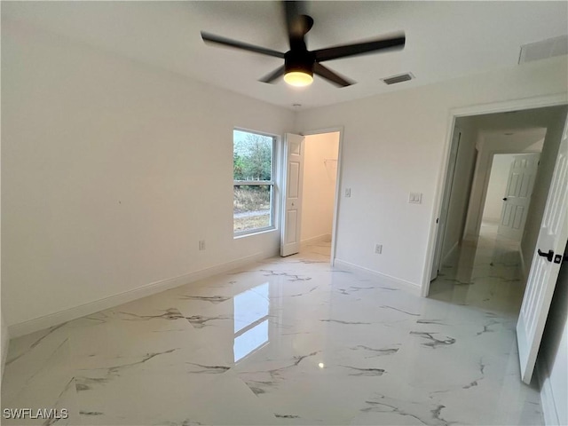 unfurnished bedroom with baseboards, a ceiling fan, and light marble finish floors