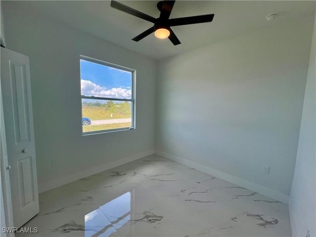 unfurnished room featuring baseboards, marble look tiles, and a ceiling fan