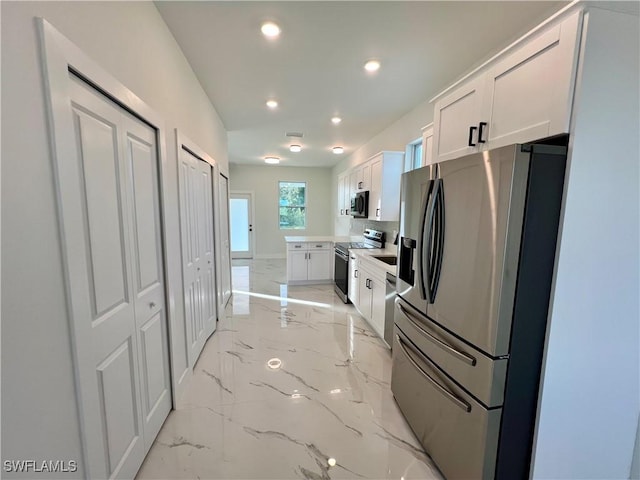 kitchen featuring appliances with stainless steel finishes, light marble finish floors, recessed lighting, white cabinets, and light countertops