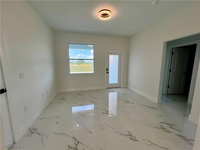 spare room with baseboards and marble finish flooring