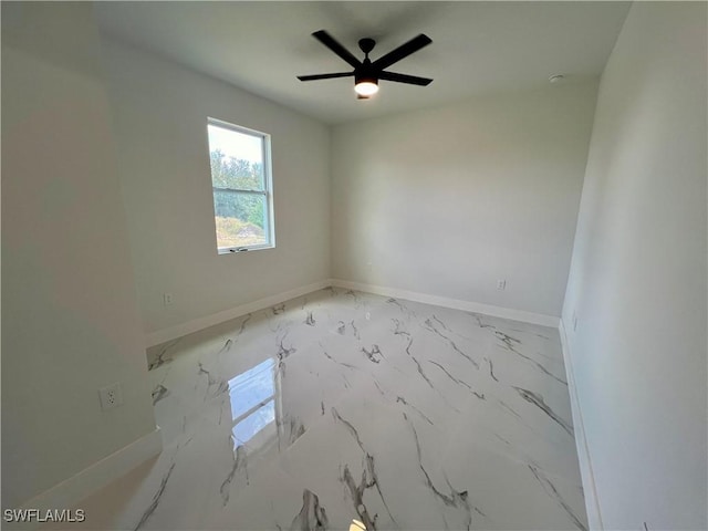 empty room featuring light marble finish floors, baseboards, and ceiling fan