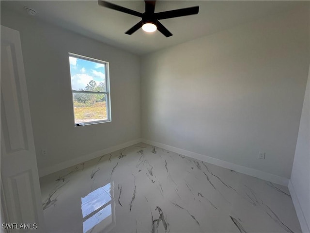 spare room with baseboards, ceiling fan, and light marble finish flooring