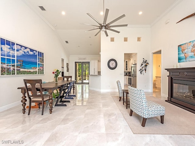 3818 2nd Ave NE, Naples, FL 34120 - dining area with baseboards, ornamental molding, high vaulted ceiling, ceiling fan, and a glass covered fireplace